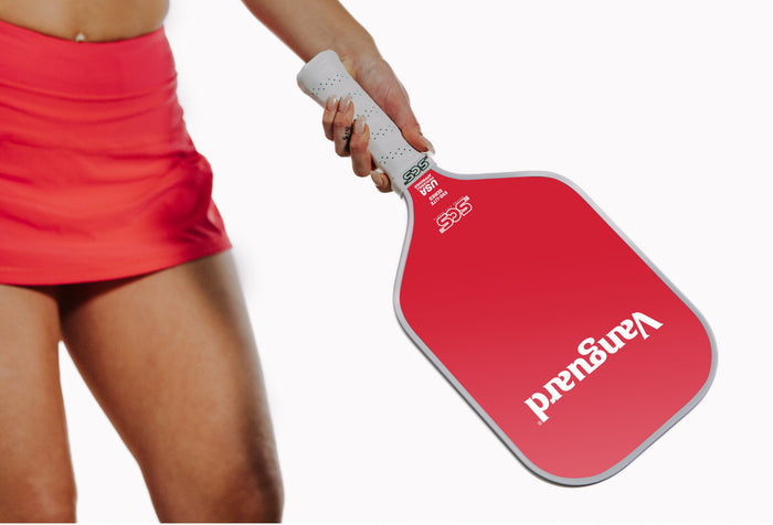 Vanguard custom branded red pickleball paddle with white handle held by a person wearing a red skirt on a white background
