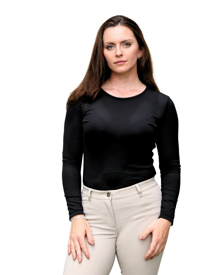 Woman wearing a black long-sleeve top and light-colored pants on a white background