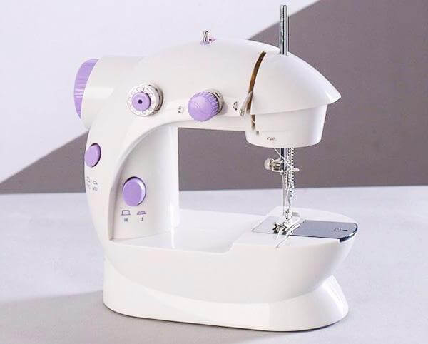 Electric Mini Household Multifunctional Sewing Machine on a table with purple accents.