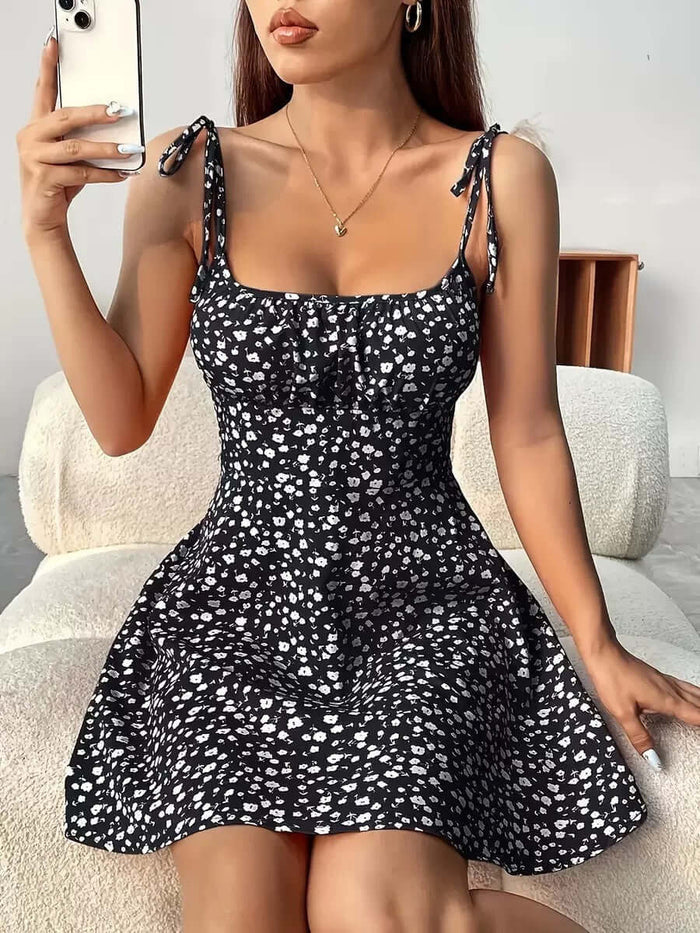 Floral Print Summer Sweet A Line Mini Dress modeled by a woman sitting and holding a phone, featuring a cute floral design.