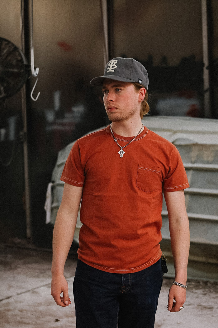 man wearing orange t-shirt on blurred background