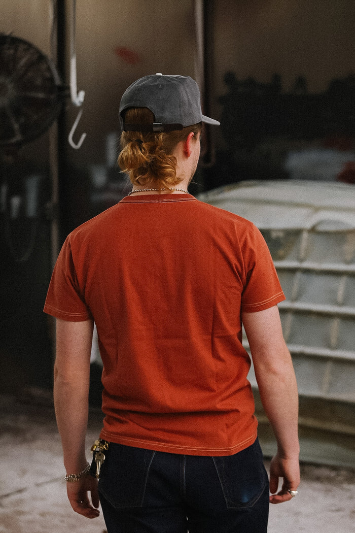 man wearing orange t-shirt on blurred background
