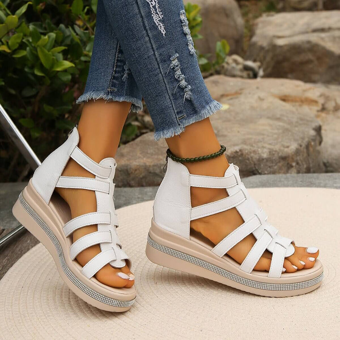 Summer Rhinestone Sandals With Back Zipper worn by a person with denim jeans on a stone surface.