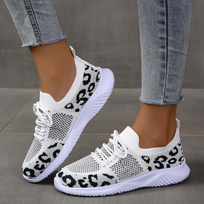 White Shoes Women Leopard Print Lace up Sneakers on a person wearing denim jeans.