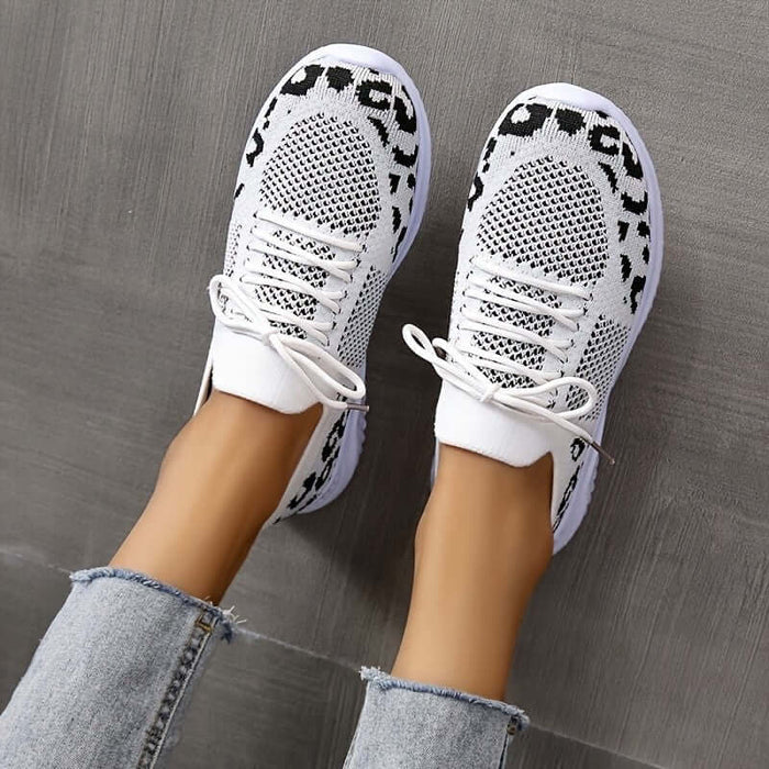 White Shoes Women Leopard Print Lace up Sneakers displayed on a model's feet with jeans.