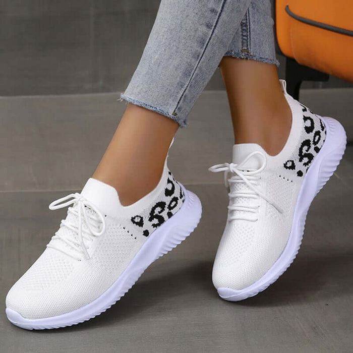White Shoes Women Leopard Print Lace up Sneakers displayed on a model's feet, showcasing a stylish and comfortable design.