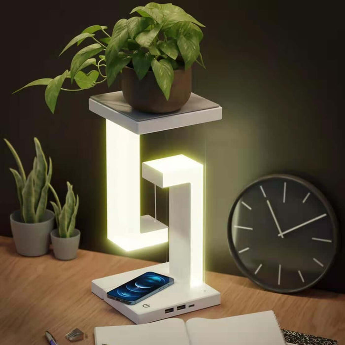 Wireless Charging Suspension Magnetic Table Lamp with plant, LED light, and modern design on a desk.