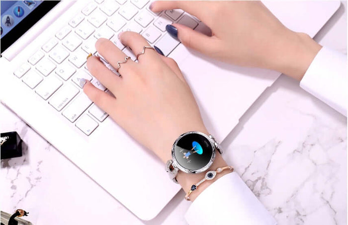 Womens Waterproof Fashion Smartwatch displayed on hand while typing on a laptop keyboard.